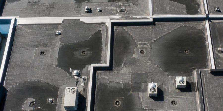 Flat commercial roof with waterproofing and HVAC units.