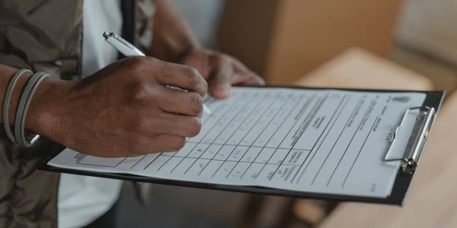 Person filling out a roof inspection form for waterproofing assessment.
